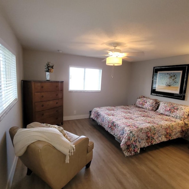 bedroom featuring ceiling fan, baseboards, and wood finished floors