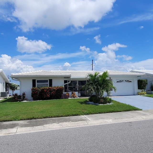 single story home featuring an attached garage, cooling unit, concrete driveway, stucco siding, and a front yard