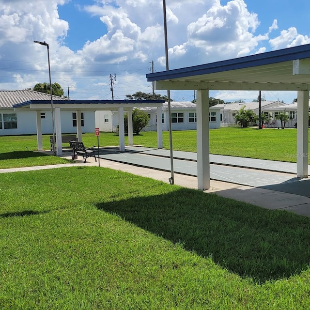 view of community featuring a lawn and shuffleboard