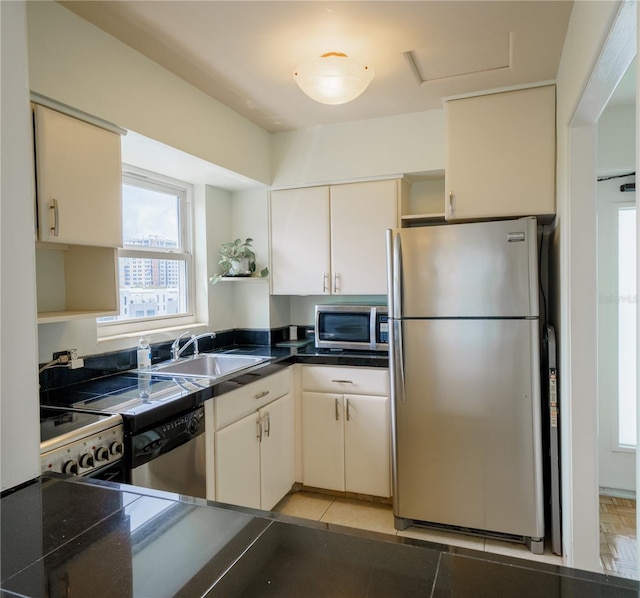 kitchen featuring dark countertops, a sink, light tile patterned flooring, stainless steel appliances, and open shelves