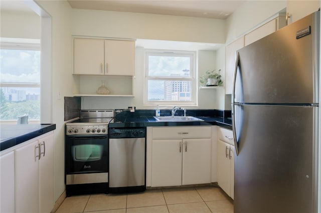 kitchen with a healthy amount of sunlight, sink, appliances with stainless steel finishes, and light tile patterned flooring