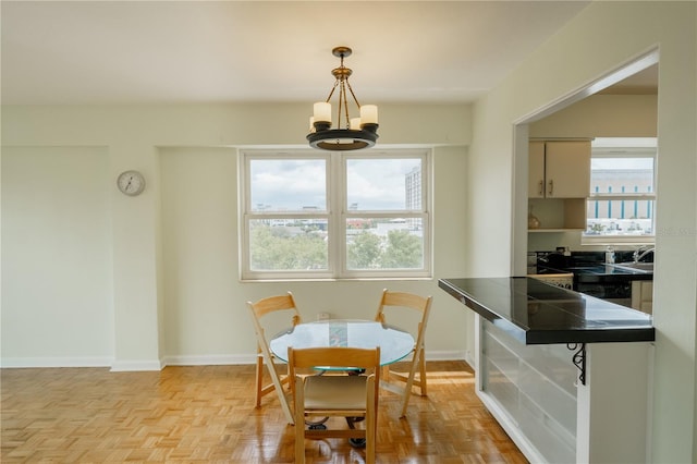 dining space with a wealth of natural light, an inviting chandelier, and light parquet floors