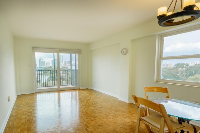 unfurnished room featuring an inviting chandelier and baseboards