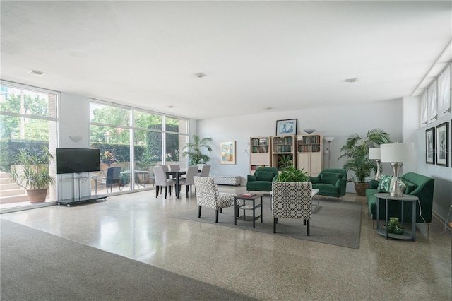 dining space featuring speckled floor and a wall of windows