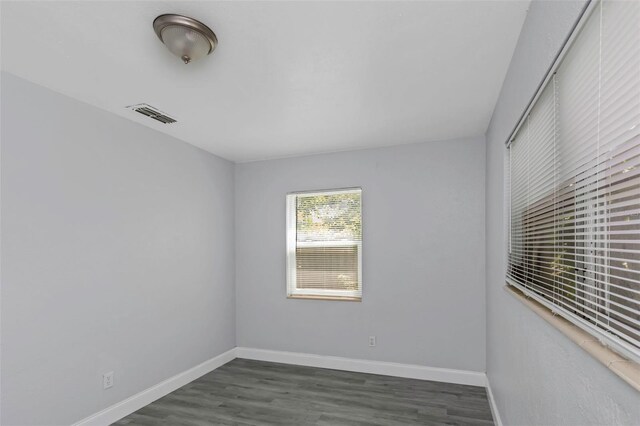 unfurnished room featuring visible vents, baseboards, and wood finished floors