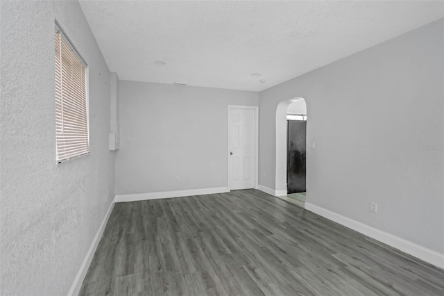 spare room featuring a textured ceiling and hardwood / wood-style floors