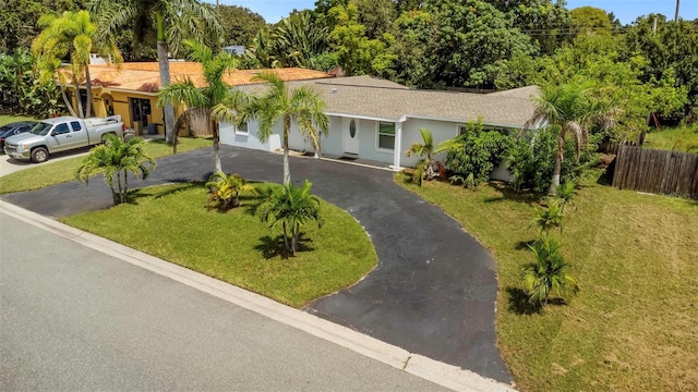 single story home featuring fence, a front lawn, and aphalt driveway