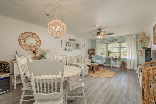 dining area with dark wood-type flooring and ceiling fan with notable chandelier