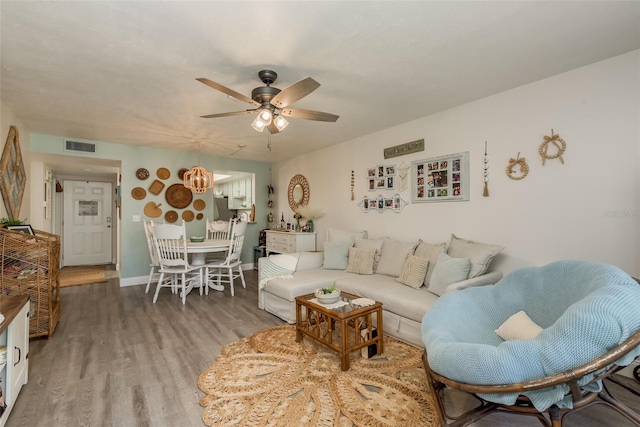 living room with ceiling fan and dark hardwood / wood-style flooring