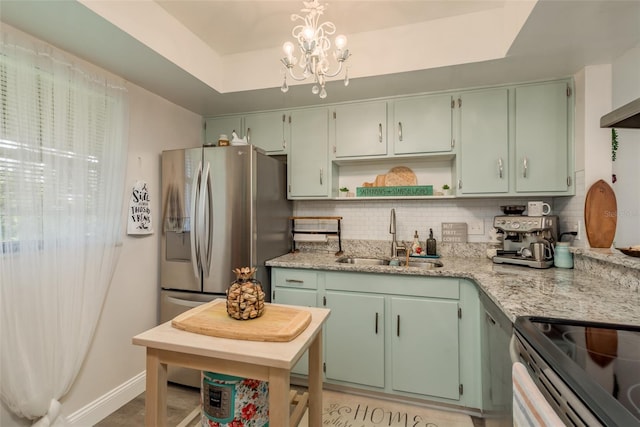 kitchen with backsplash, a raised ceiling, a notable chandelier, and sink