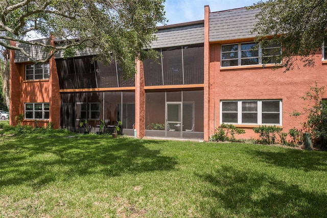 back of property featuring a yard and a sunroom