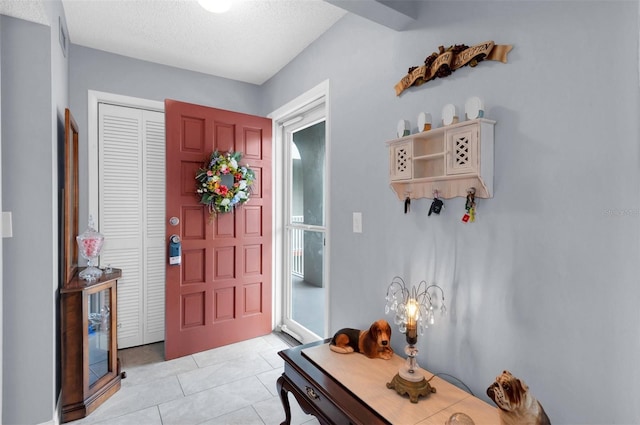 tiled entrance foyer featuring a textured ceiling