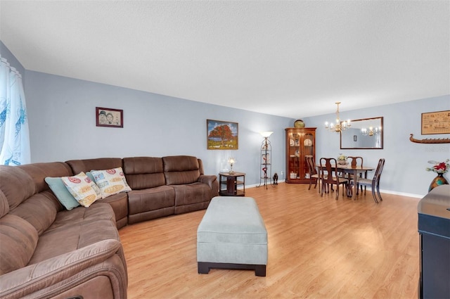 living room with light wood-type flooring, a textured ceiling, and a notable chandelier