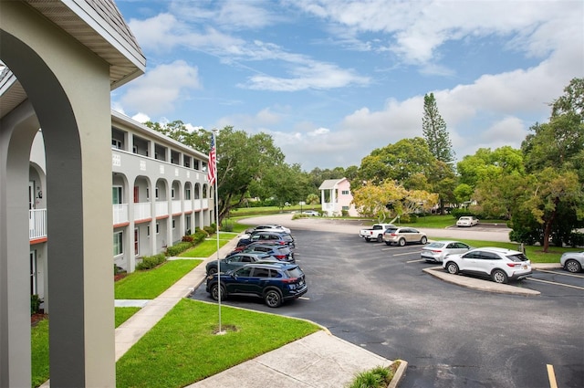 view of parking / parking lot with a lawn