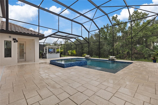 view of swimming pool with glass enclosure, an in ground hot tub, pool water feature, and a patio