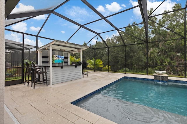 view of pool featuring a patio area, pool water feature, exterior bar, and glass enclosure