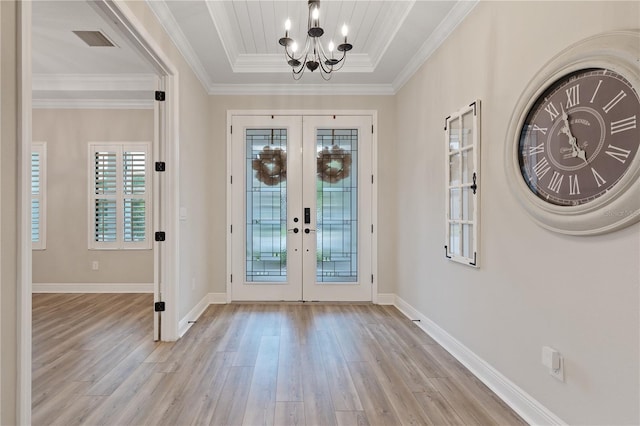 entryway with a chandelier, french doors, ornamental molding, and light hardwood / wood-style flooring