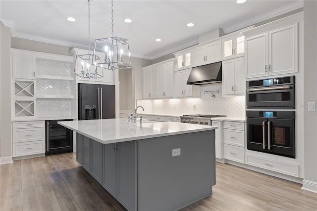 kitchen featuring white cabinetry, sink, wine cooler, a center island with sink, and appliances with stainless steel finishes