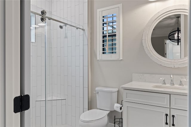 bathroom with toilet, vanity, and tiled shower