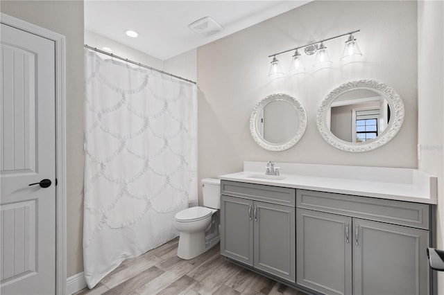 bathroom with toilet, vanity, a shower with shower curtain, and hardwood / wood-style flooring