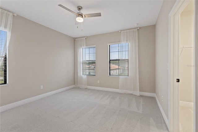 carpeted spare room with ceiling fan