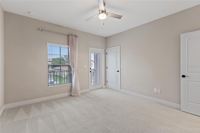 carpeted spare room with ceiling fan