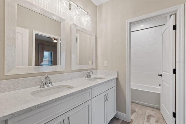 bathroom with hardwood / wood-style floors, vanity, and shower / tub combination