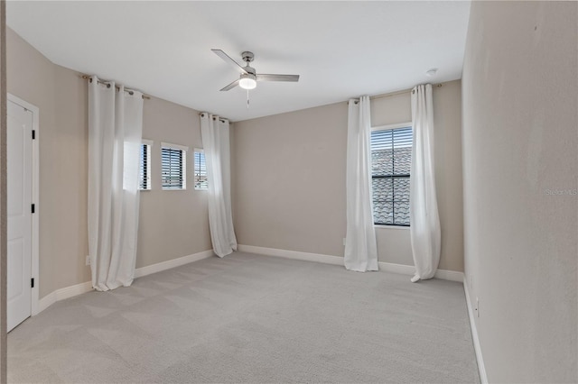 carpeted spare room featuring ceiling fan and a healthy amount of sunlight