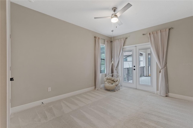 unfurnished room featuring ceiling fan, french doors, and light colored carpet