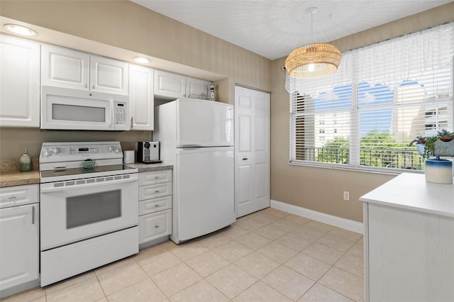 kitchen featuring white appliances, decorative light fixtures, and white cabinets