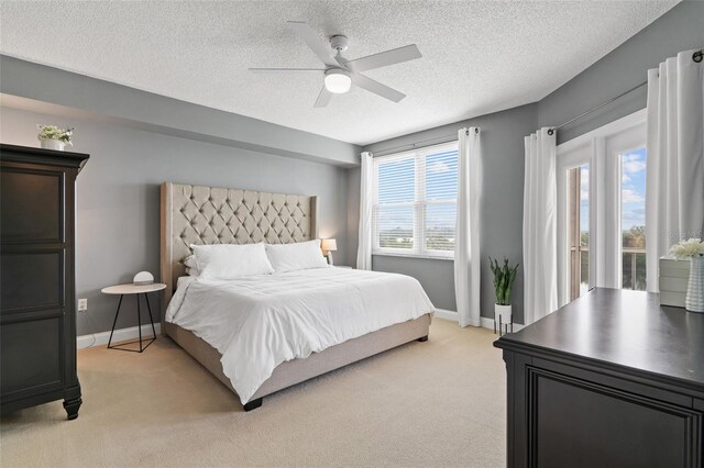 carpeted bedroom with a textured ceiling, access to outside, and ceiling fan