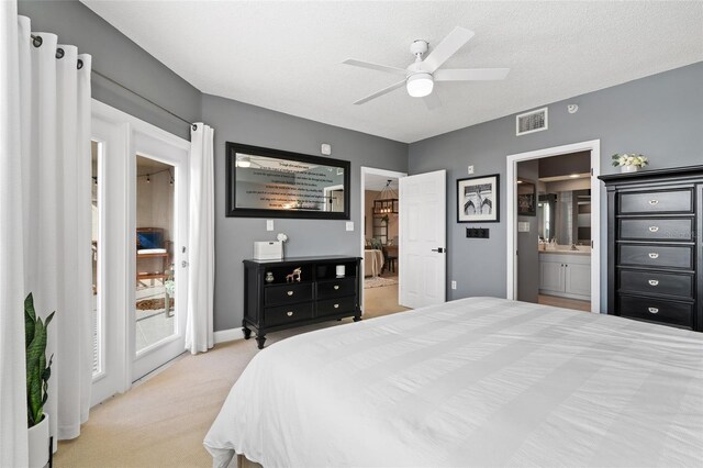 carpeted bedroom with ceiling fan, a textured ceiling, ensuite bathroom, and access to exterior