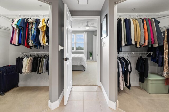 walk in closet with light colored carpet and ceiling fan