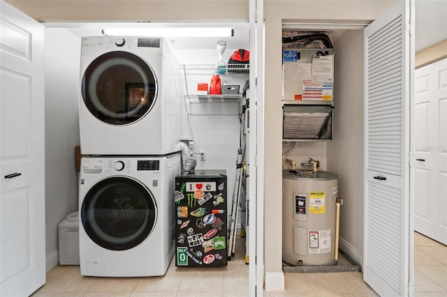 laundry area featuring electric water heater, light tile patterned floors, and stacked washing maching and dryer