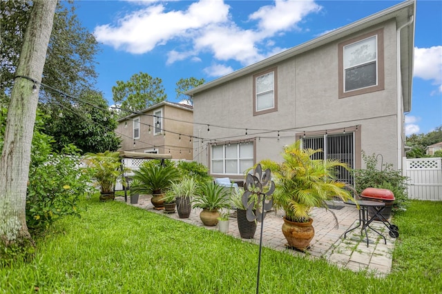 back of property with a patio and a lawn