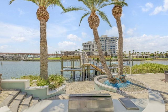 view of patio with a water view and a dock