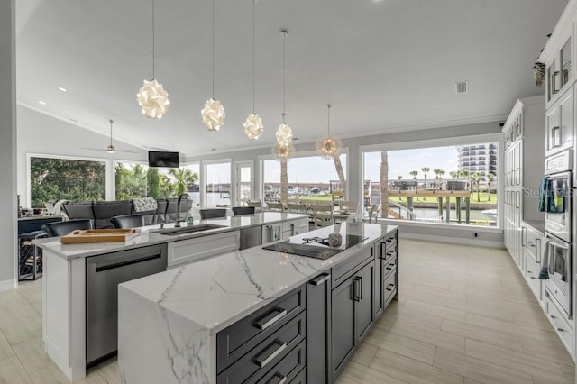 kitchen with a healthy amount of sunlight, sink, a center island, and white cabinetry