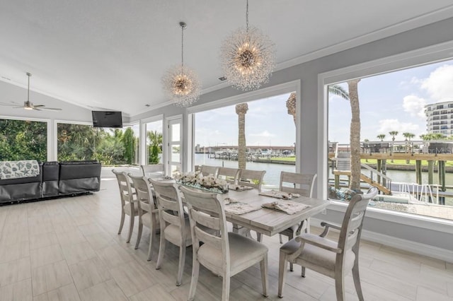 dining area with crown molding, plenty of natural light, vaulted ceiling, and ceiling fan with notable chandelier