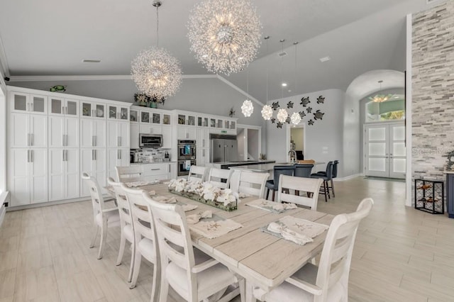 dining room featuring crown molding, high vaulted ceiling, and an inviting chandelier