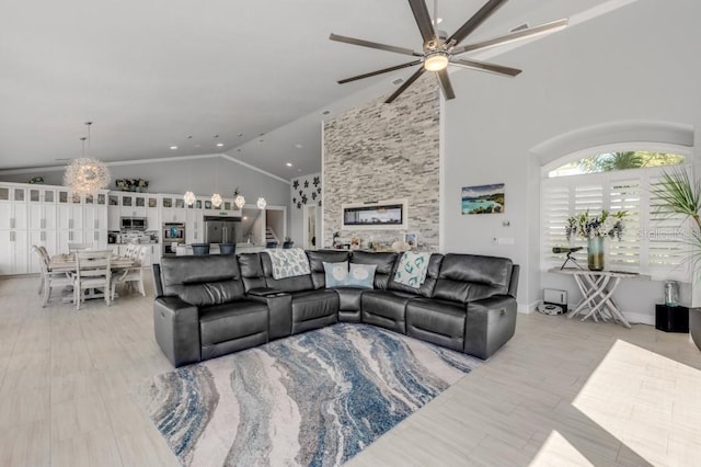 living room with high vaulted ceiling and ceiling fan with notable chandelier