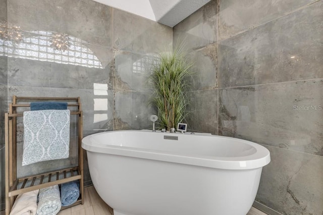 bathroom featuring tile walls and a bathing tub