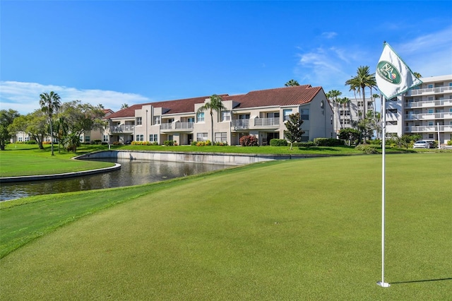 view of community featuring a water view and a lawn