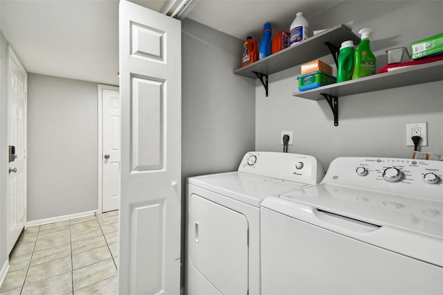 clothes washing area featuring washing machine and dryer and light tile patterned floors