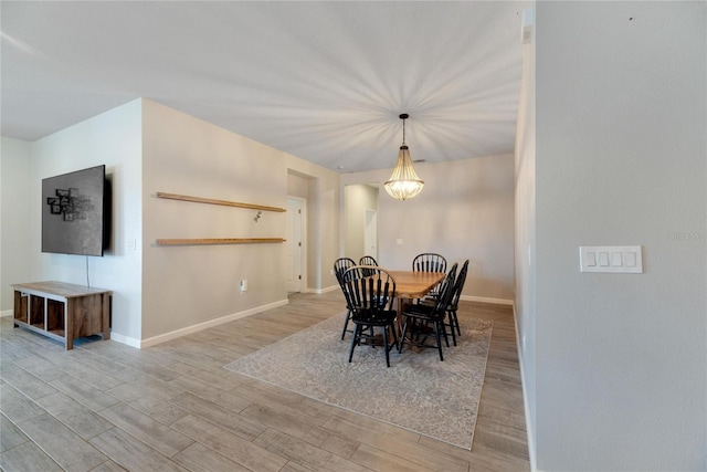 dining room with light hardwood / wood-style flooring and a chandelier