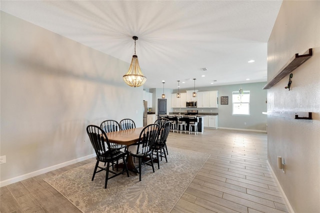 dining space featuring light hardwood / wood-style flooring and an inviting chandelier