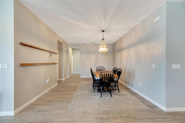 dining space with light hardwood / wood-style flooring and an inviting chandelier