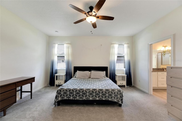 bedroom with ceiling fan, ensuite bathroom, and light carpet