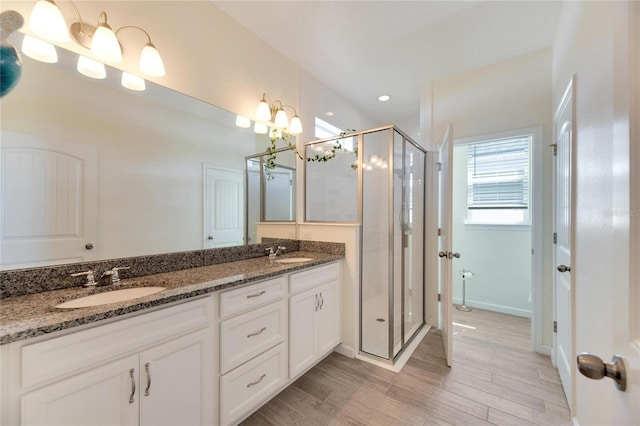 bathroom featuring an enclosed shower, hardwood / wood-style flooring, a chandelier, and vanity