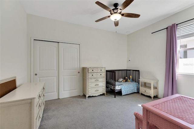 bedroom with a closet, ceiling fan, and light colored carpet