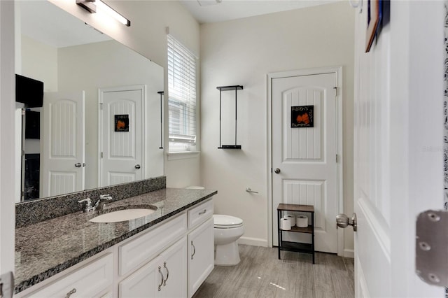 bathroom featuring vanity, toilet, and hardwood / wood-style floors